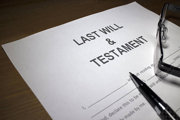 Someone filling out Last Will and Testament document.